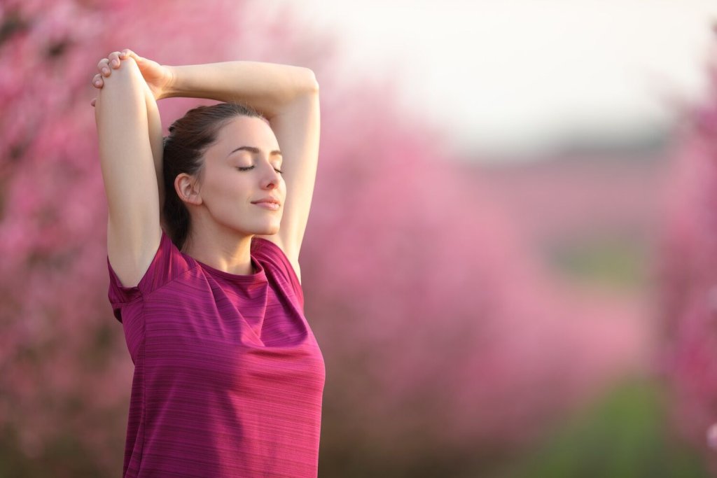 Sportswoman,Stretching,Arms,And,Relaxing,In,A,Field,After,Sport