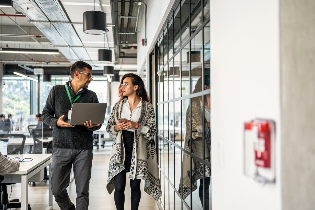 Coworkers talking while walk through office