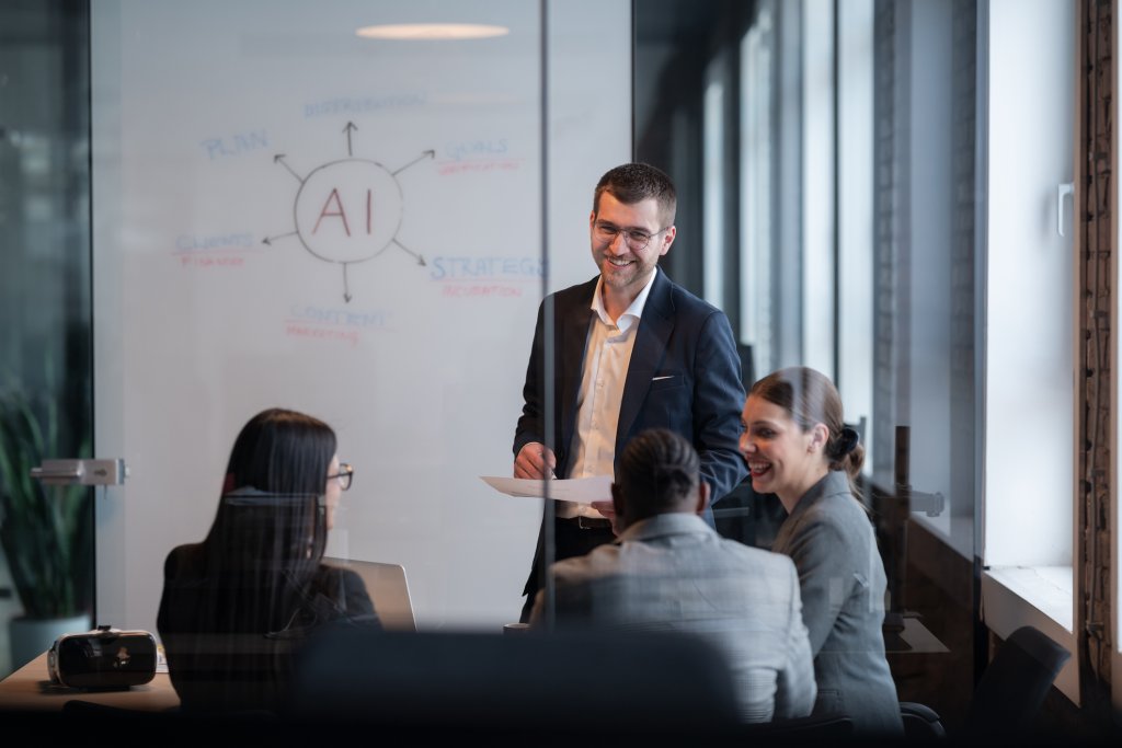 Diverse business team in a modern office during a meeting, discussing artificial intelligence strategy. Concept of AI innovation, teamwork, leadership, corporate planning, professional collaboration